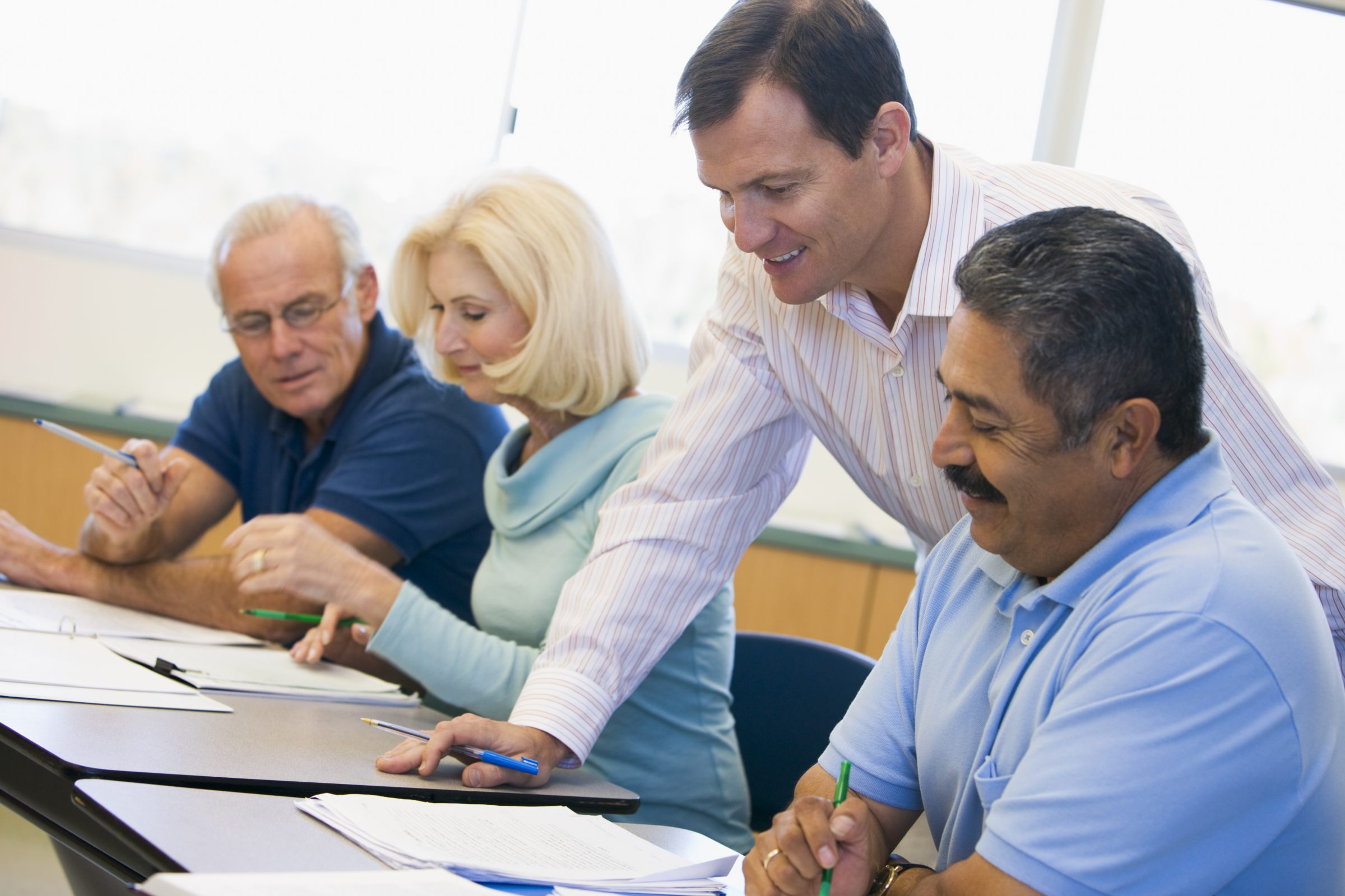 Teacher assisting adult student in class